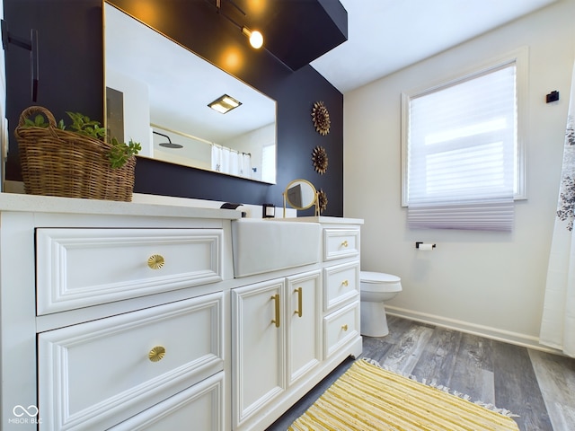 bathroom with vanity, toilet, curtained shower, and wood-type flooring