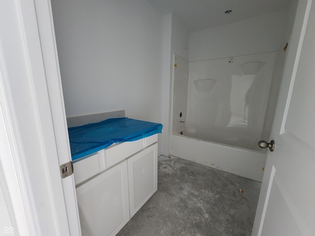 bathroom featuring vanity, tub / shower combination, and concrete flooring