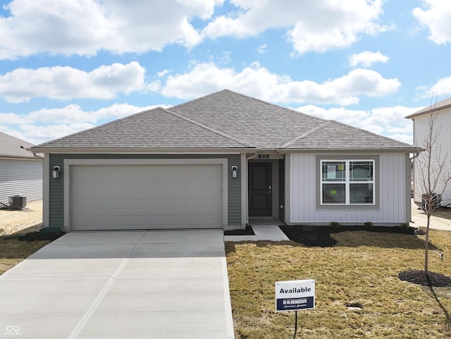 single story home featuring an attached garage, central air condition unit, a shingled roof, driveway, and a front yard