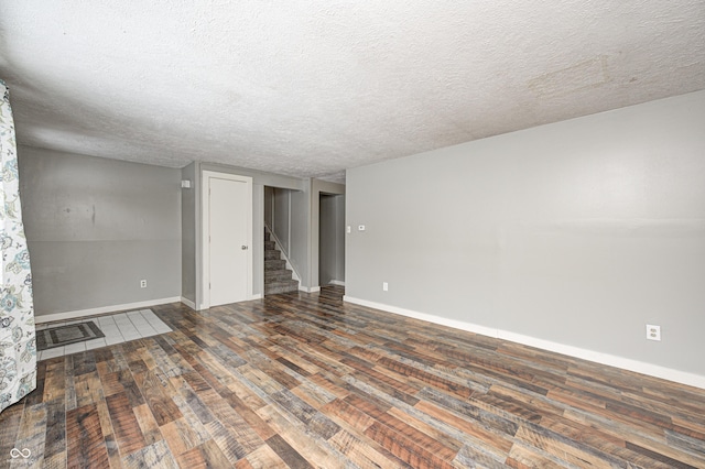 spare room with dark hardwood / wood-style flooring and a textured ceiling