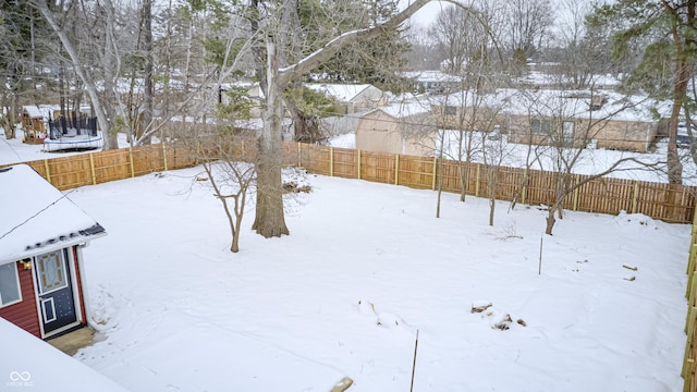 yard layered in snow with a trampoline