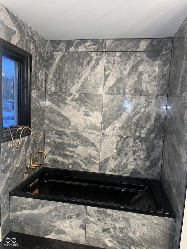 bathroom featuring tile walls and a bathing tub