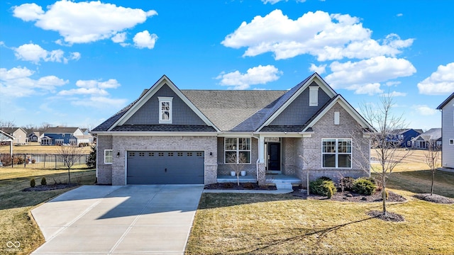 craftsman house with brick siding, a garage, concrete driveway, a front yard, and fence