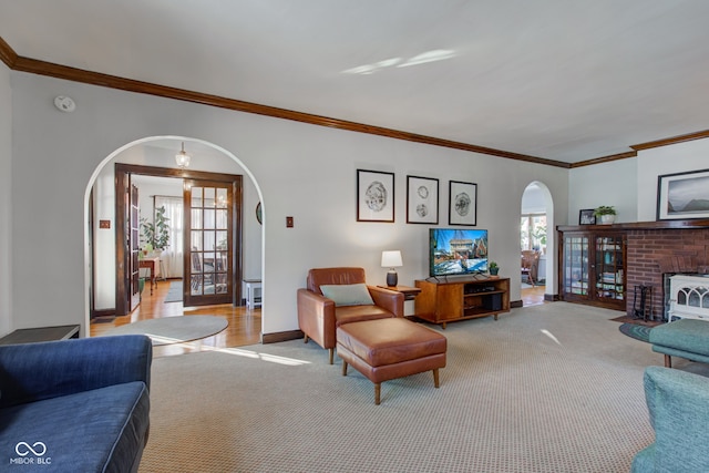 living room featuring a wealth of natural light, light colored carpet, and ornamental molding