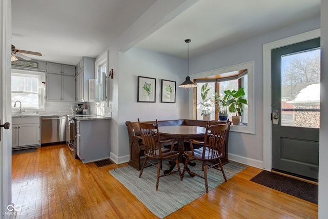 dining area featuring light wood-type flooring, plenty of natural light, and sink