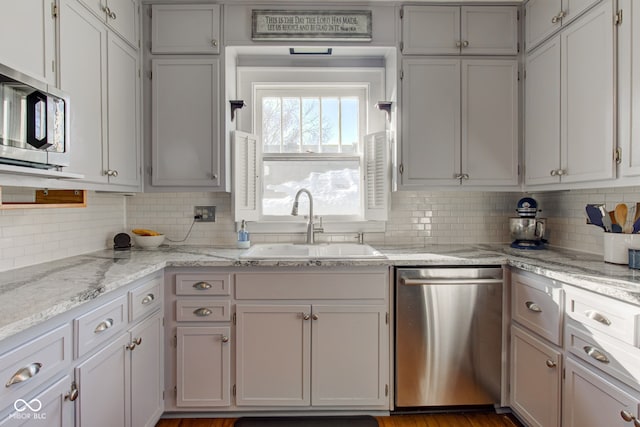 kitchen with stainless steel appliances, white cabinetry, tasteful backsplash, and sink