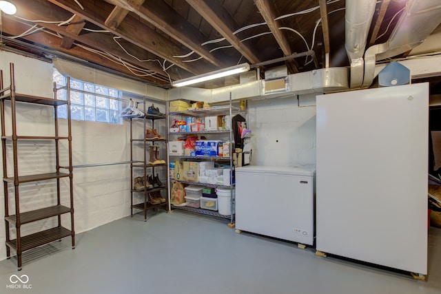 basement featuring white refrigerator and refrigerator