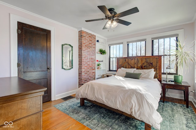 bedroom with ceiling fan, crown molding, and light hardwood / wood-style flooring