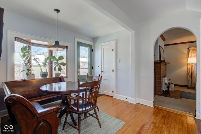 dining space with a fireplace and light hardwood / wood-style flooring