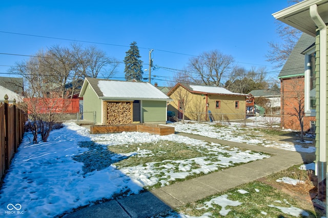 yard layered in snow featuring an outbuilding