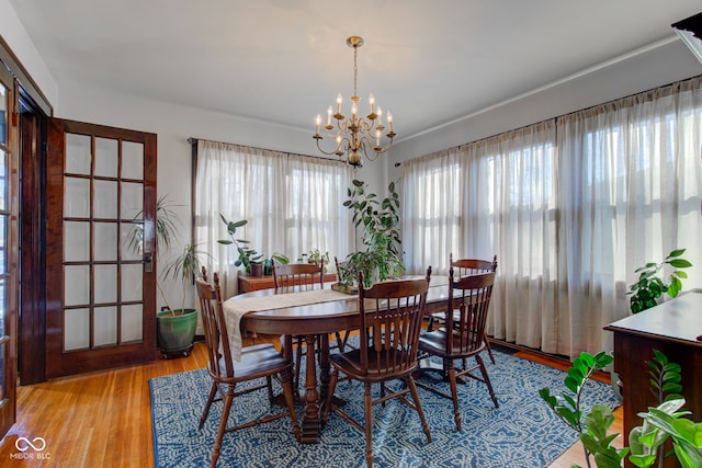 dining space with an inviting chandelier and light hardwood / wood-style floors