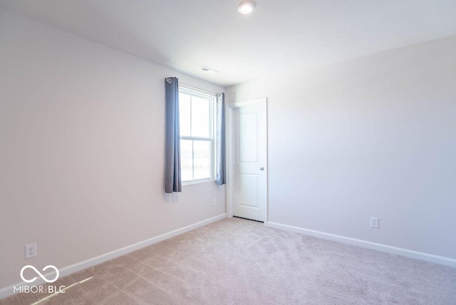 unfurnished room featuring light carpet