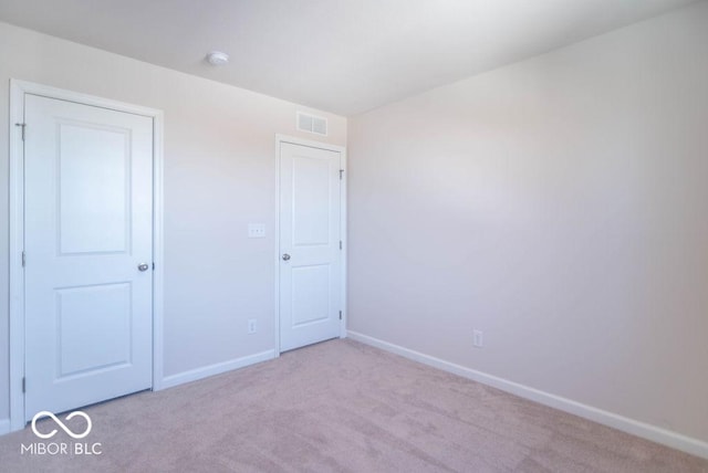 unfurnished bedroom with light colored carpet