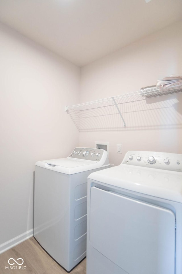 laundry area featuring light wood-type flooring and washing machine and clothes dryer