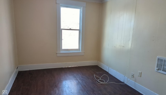 spare room featuring dark wood-type flooring and heating unit