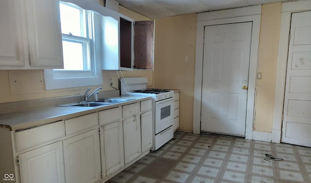 kitchen with sink, white cabinetry, and white range with gas cooktop