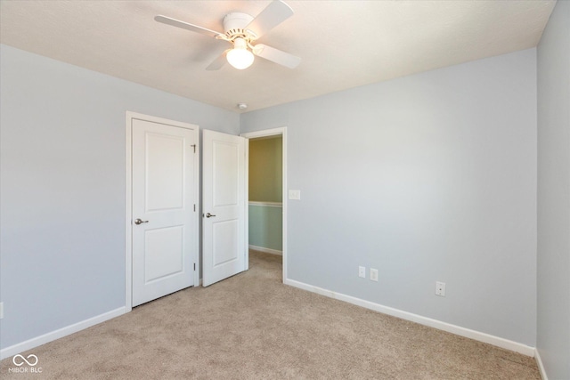 empty room with ceiling fan and light carpet