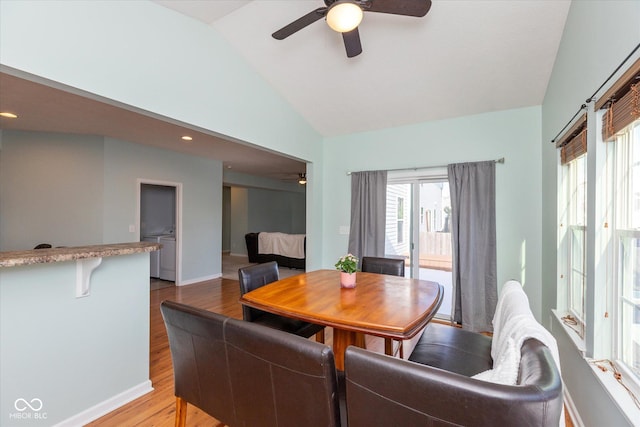 dining room featuring ceiling fan, vaulted ceiling, and light wood-type flooring