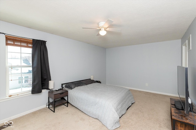 bedroom with ceiling fan and light carpet