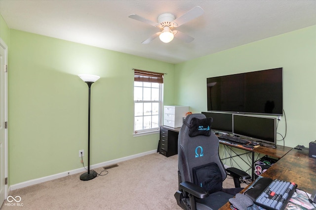 carpeted home office featuring ceiling fan