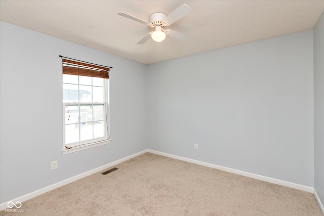 carpeted spare room featuring ceiling fan