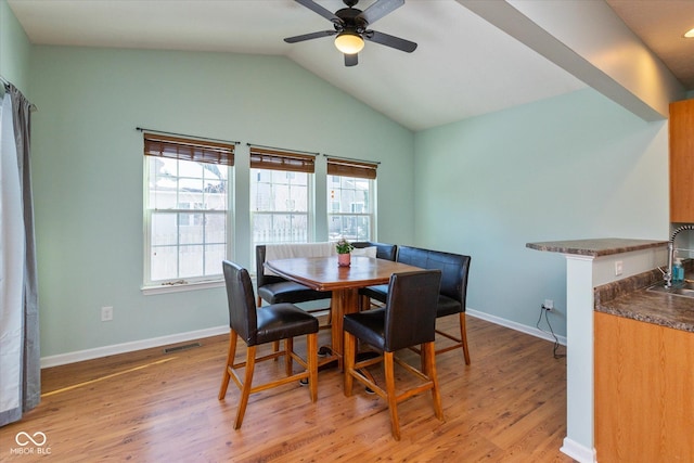 dining area with lofted ceiling, sink, light hardwood / wood-style flooring, and ceiling fan