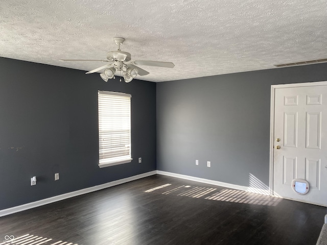 empty room featuring ceiling fan, a textured ceiling, and dark hardwood / wood-style flooring