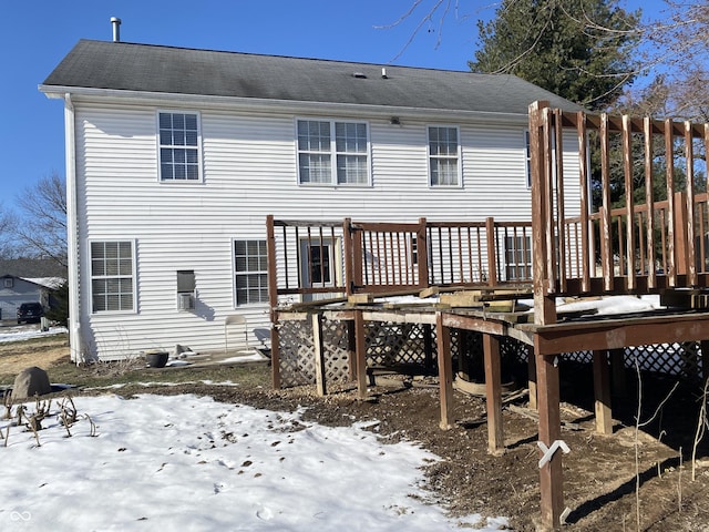 snow covered rear of property featuring a wooden deck