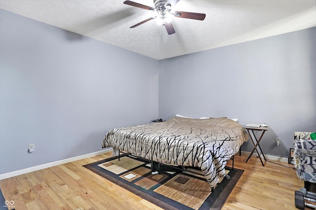 bedroom with light wood-type flooring, a textured ceiling, and ceiling fan