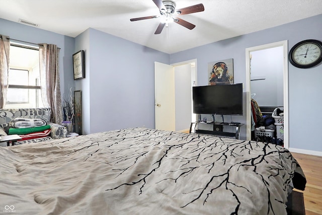 bedroom featuring wood-type flooring, a textured ceiling, and ceiling fan