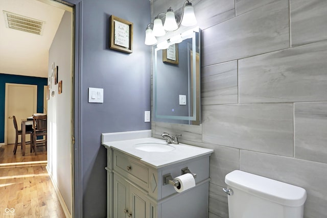 bathroom featuring wood-type flooring, vanity, and toilet