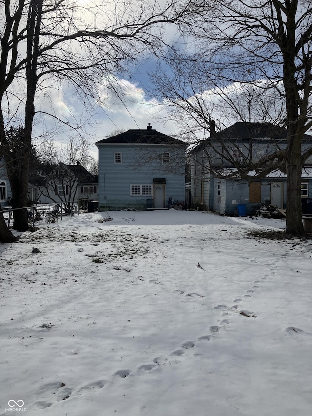 view of snow covered rear of property