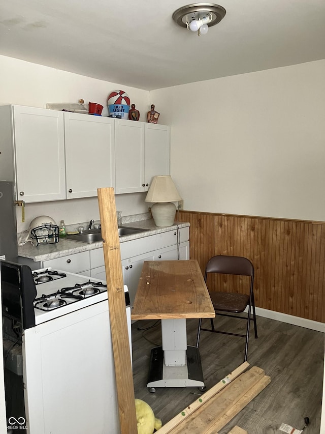 interior space with dark wood-type flooring, white cabinetry, and white range with gas cooktop