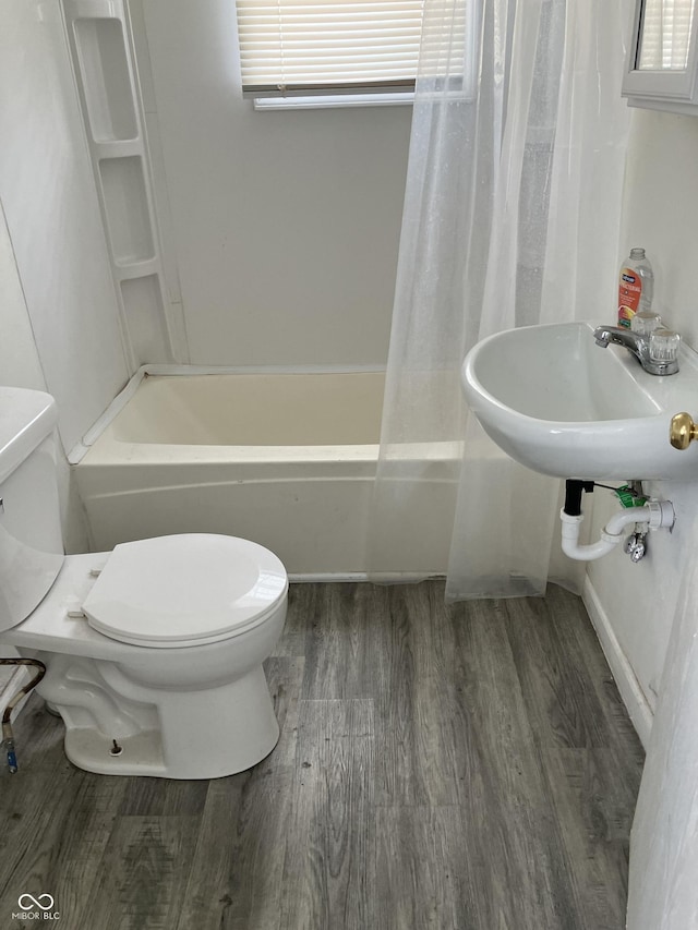 full bathroom with hardwood / wood-style flooring, sink, toilet, and shower / tub combo with curtain