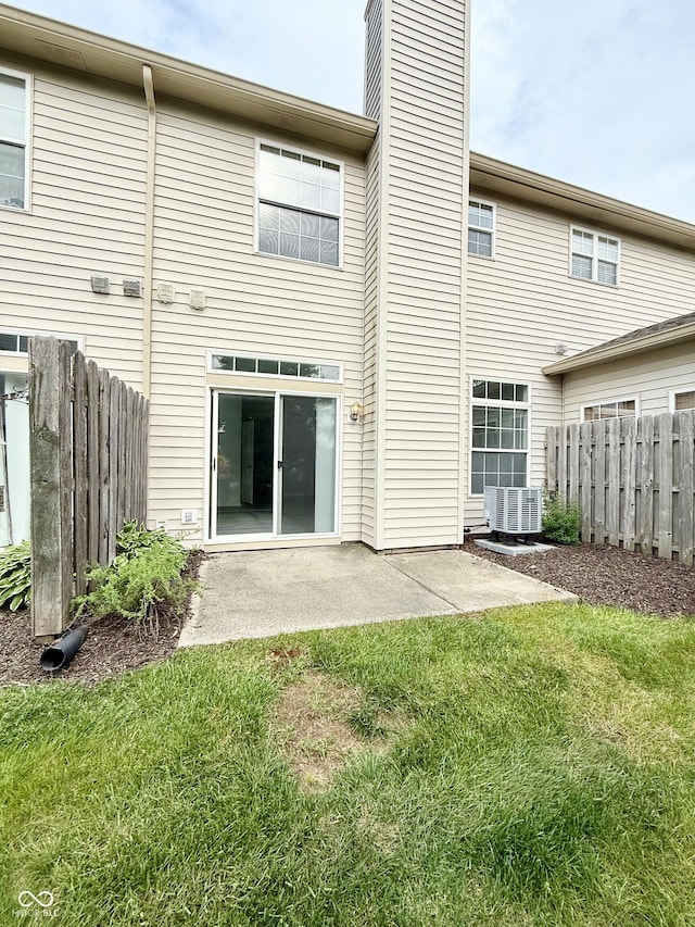 7042 Tyler Ln, Indianapolis, IN 46217 - rear view of property featuring a chimney, a patio, and central AC