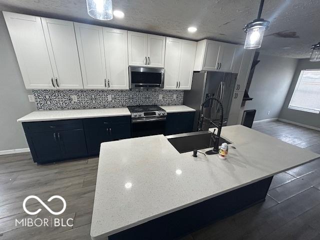 kitchen featuring white cabinetry, hardwood / wood-style floors, and appliances with stainless steel finishes