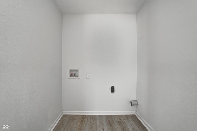 clothes washing area featuring washer hookup and light hardwood / wood-style flooring