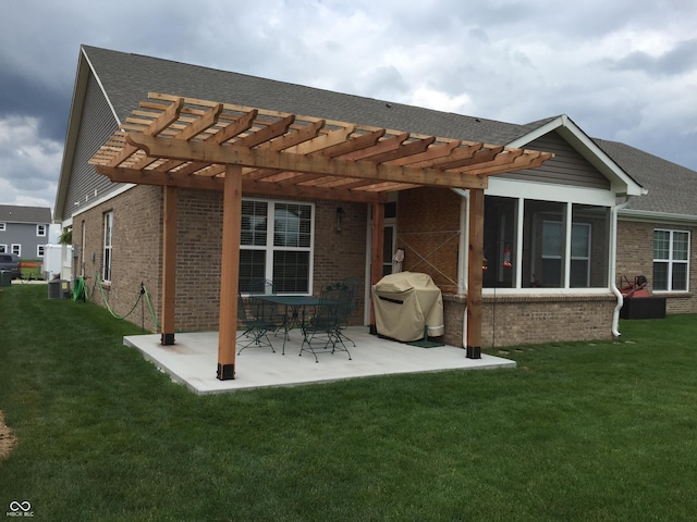 rear view of house with a sunroom, a pergola, a patio area, and a lawn