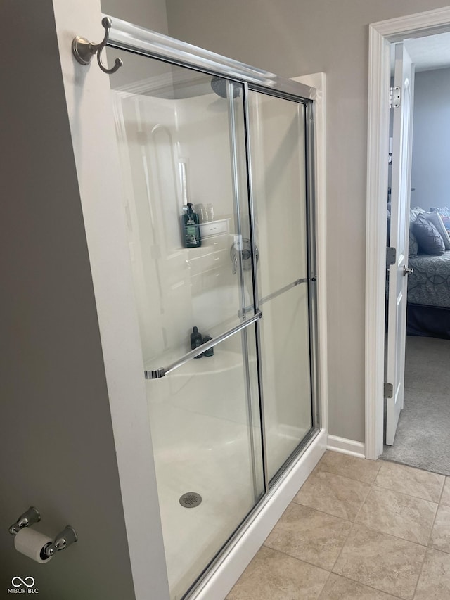 bathroom with walk in shower and tile patterned flooring