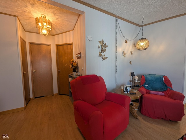 sitting room with ornamental molding, wood-type flooring, and a textured ceiling