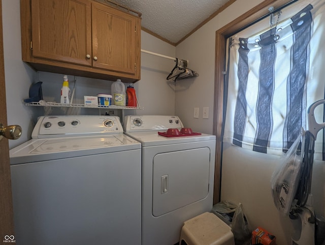 laundry area featuring cabinets, ornamental molding, washer and dryer, and a textured ceiling