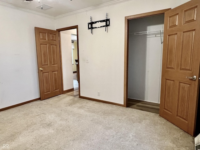 unfurnished bedroom featuring light carpet, ornamental molding, and a closet