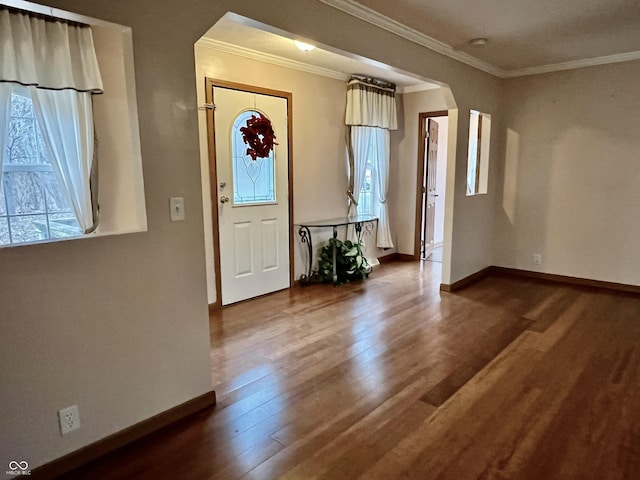 entryway with arched walkways, plenty of natural light, baseboards, and wood finished floors