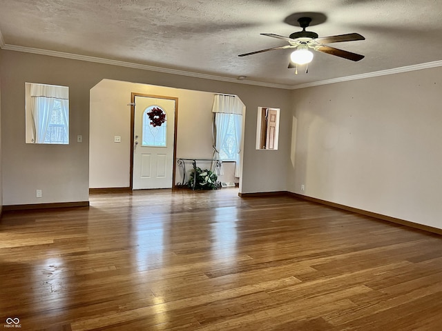 foyer entrance featuring hardwood / wood-style floors, crown molding, and plenty of natural light