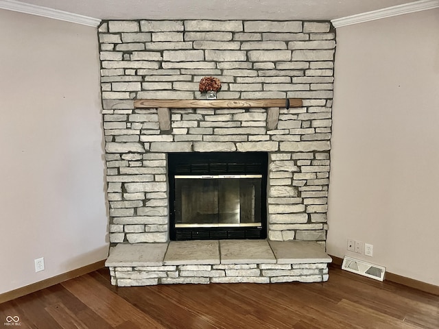 details with wood finished floors, a fireplace, visible vents, and ornamental molding