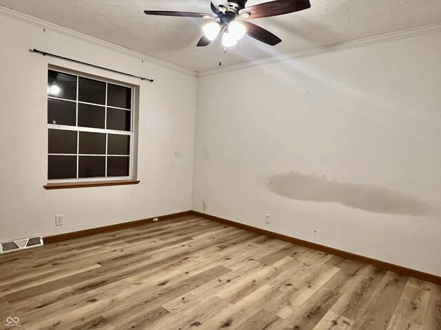 unfurnished room featuring crown molding, wood finished floors, visible vents, and a textured ceiling