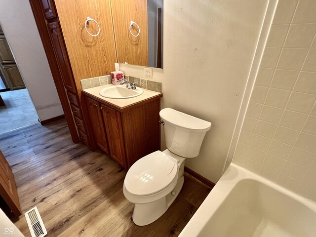 full bathroom with visible vents, toilet, vanity, and wood finished floors