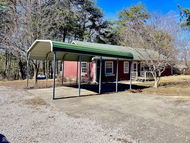 view of front of home with a carport and gravel driveway