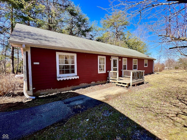 view of front facade featuring a deck and a shingled roof