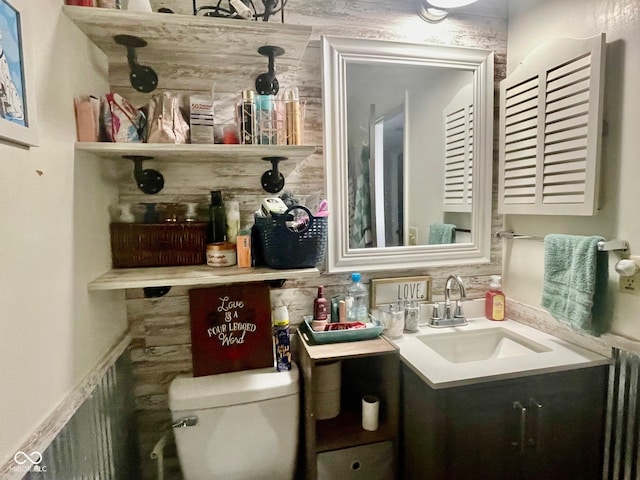 bathroom with toilet, vanity, and radiator